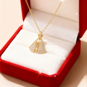 Goldene Halskette mit religiösem Anhänger und Kristallen auf einer Samt-Schmuckschatulle