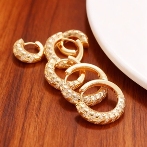 Chique gouden oorringen met diagonale micro-pavé zirkoon op houten achtergrond