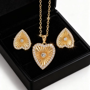 Vista detallada de un conjunto de joyas de corazón dorado con collar y pendientes