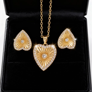 Detalle del conjunto de joyas de corazón dorado con circonitas blancas en terciopelo