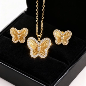 Primer plano del set de joyas mariposa dorada con circones en estuche de terciopelo