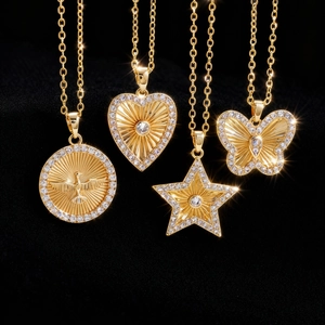 Detalle de cuatro colgantes dorados con estrella, corazón, mariposa y paloma con circonitas