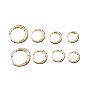 Lot de quatre paires de boucles d'oreilles créoles dorées de différentes tailles sur blanc