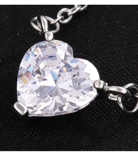 Primer plano de colgante de corazón de circón con engaste de tres garras en cadena de plata