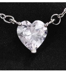 Vista macro del colgante de corazón de circón brillante con cadena de plata y engaste de tres garras
