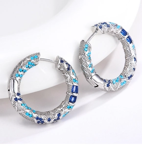 Dettaglio di orecchini a cerchio in argento con cristalli blu zaffiro e pavé azzurro