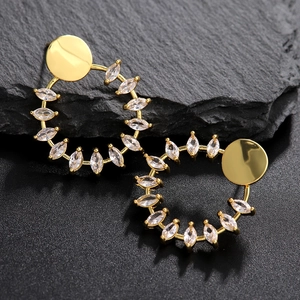 Elegantes pendientes redondos bañados en oro con circonitas marquesa sobre base oscura