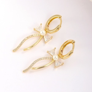 Boucles d'oreilles nœud dorées avec zircons triangles, perle et pampilles scintillantes