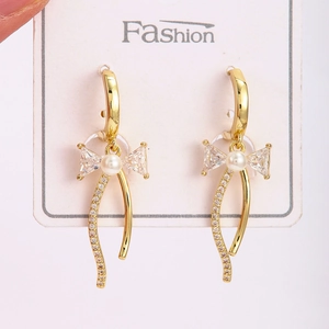 Boucles d'oreilles nœud dorées avec perles et zircons cubiques de style huggie chic