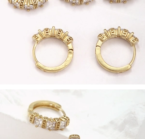 Detail of gold hoop earrings with square zircon stones and spring closure mechanism