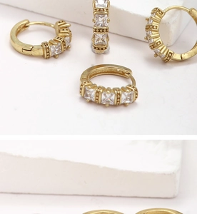 Detailed shot of brass earrings with square-cut zircons and beaded edge on stone blocks