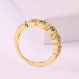 Elegante anillo de oro con piedras verdes onduladas y circones rosas en base rosa
