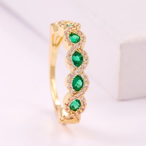 Anillo dorado con piedras ovaladas verde esmeralda y detalles de circonitas pavé