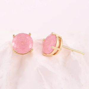 Primo piano di orecchini a perno con cristallo rosa tondo e castone a quattro griffe