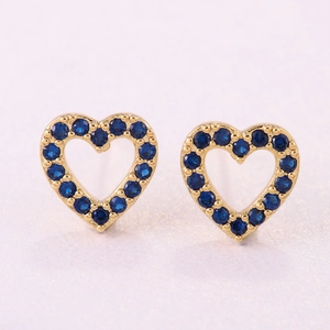 Nahaufnahme herzförmiger Goldstecker mit tiefblauen Zirkoniasteinen in Pavé-Fassung