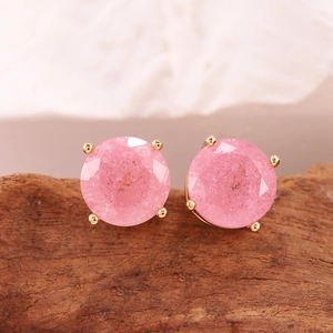Vista macro di orecchini con pietre rosa e castone a quattro griffe dorate su legno