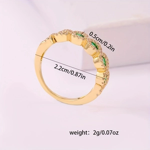 Anello di fidanzamento dorato con zircone verde smeraldo e fascia intrecciata micro-pavé