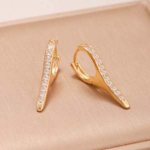 Macro shot of gold-plated hoop earrings with streamlined zircon stones inlay