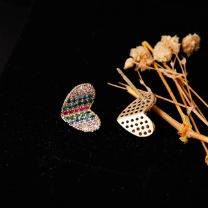Dettaglio ravvicinato di orecchini a cuore in oro con pavé di zirconi colorati