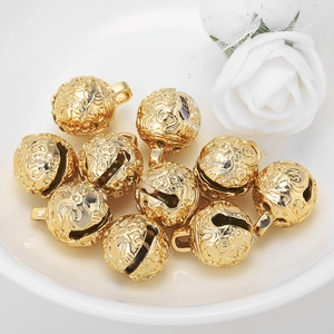 Golden metal charms with star engraving for DIY jewelry making displayed on white plate