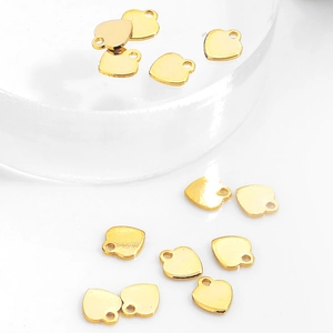 Polished gold heart pendants for DIY jewelry making displayed on a white background