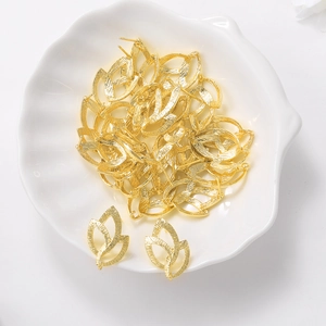 Golden leaf-shaped metal earring studs for DIY jewelry making displayed on a tray