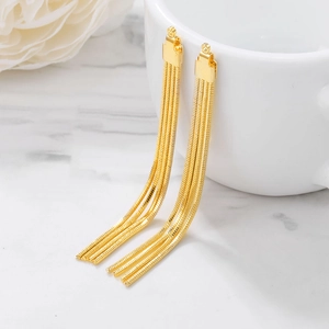 Elegant gold-plated metal tassel earrings with sleek snake chain pendants on marble desk