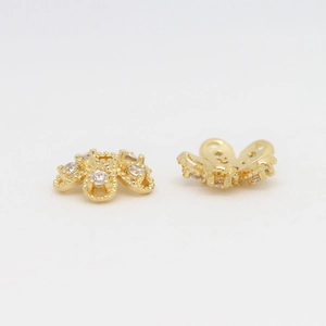 Detailed close-up of gold-plated flower bead caps with sparkling zircon accents