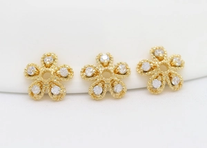 Macro shot of three gold plated flower bead caps with zircon crystals for DIY jewelry