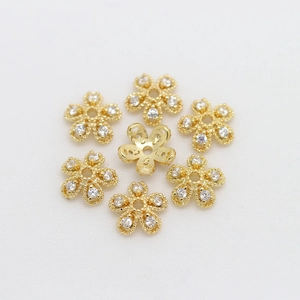 Macro shot of 18K gold-plated flower bead caps with zircon petal inlay for DIY jewelry
