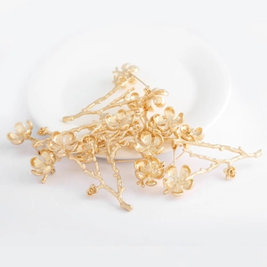 Detail of gold-plated plum blossom branch brooches with matte and polished texture