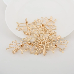 Golden tree branch brooch accessories with leaf textures on a white round plate