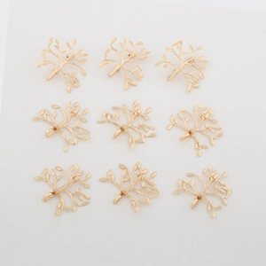 Detail of 9-piece golden tree brooches with safety pin and pendant loop on white background