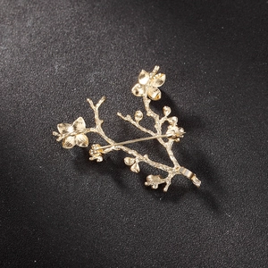 Detail of gold floral brooch back showing rotating safety clasp and metallic texture