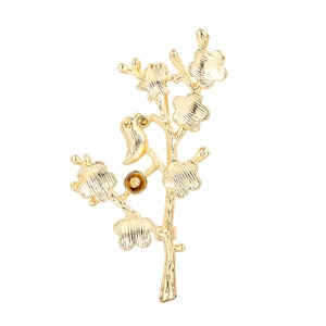 Golden plum blossom branch brooch with a small bird on a white background