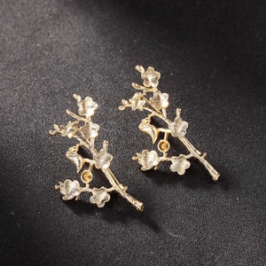 Detailed close-up of gold-plated flower branch brooch components with fine metal textures