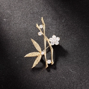 Broche élégante en bambou et fleur en métal doré sertie de cristaux de zircone brillants