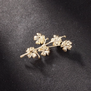 Macro detail of the back structure and horizontal pin clasp on a gold flower brooch