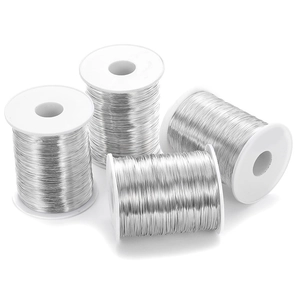 Vier rollen zilveren koperdraad op plastic spoelen voor het maken van DIY-sieraden