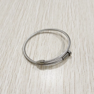 Dettaglio ravvicinato di un bracciale a chiodo in filo di acciaio intrecciato argento