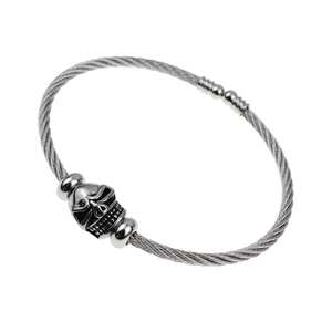 Macro detail of retro stainless steel cable bracelet with antique skull charm focal point