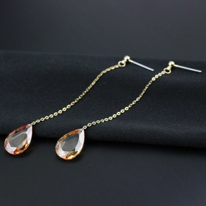 Detailansicht der bernsteinfarbenen Tropfen-Ohrringe mit eleganten goldenen Ketten