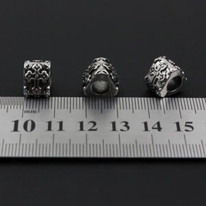 Macro view of cross engraved stainless steel beads showing 10mm size on a ruler