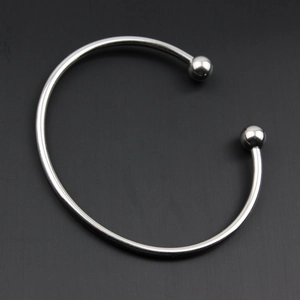 Vista dettagliata dall'alto di un bracciale rigido aperto in acciaio inox argento