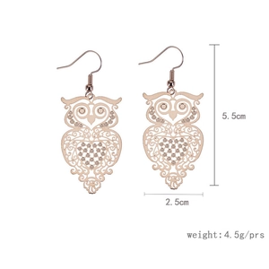 Detailed view of rose gold owl earrings with intricate hollow-cut metal texture and sizing