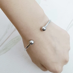 Dettaglio del bracciale aperto in acciaio al titanio argento con sfere indossato al polso