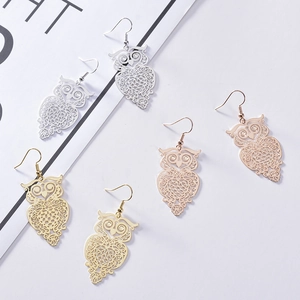 Detailed view of hollow owl drop earrings in silver, gold and rose gold finishes