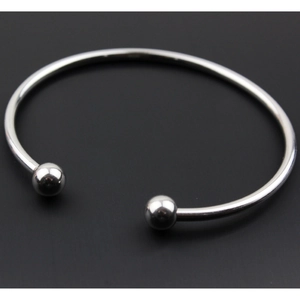 Vista macro del bracciale aperto in acciaio inossidabile lucido con punte a sfera