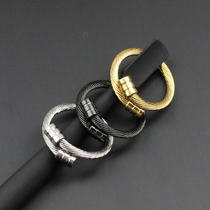 Détail de bagues torsadées en or, argent et noir avec un design industriel moderne