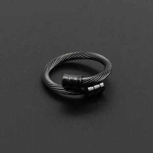 Vue détaillée de la texture de câble noir et du design en spirale sur la bague en acier
